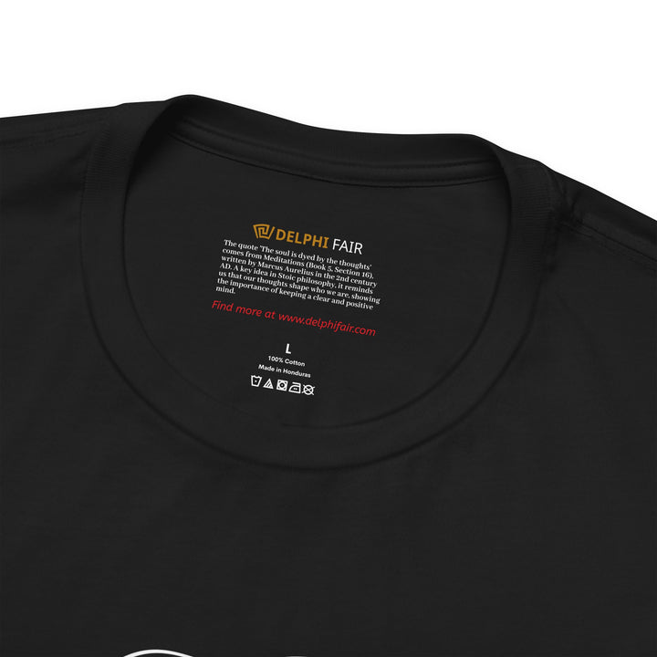 Close-up of black t-shirt neck label with the phrase 'The soul is dyed by the thoughts' and a brief note about its origin from Marcus Aurelius.