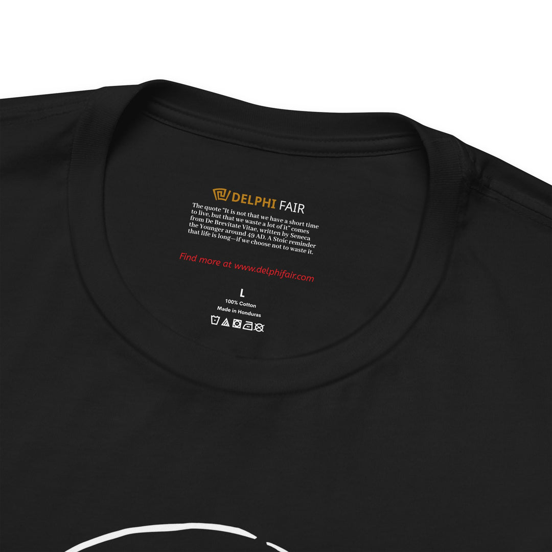 Close-up of a black t-shirt neck label featuring the phrase 'It is not that we have a short time to live, but that we waste a lot of it,' with a note about its meaning and origin from Seneca's letters written around 49 AD."