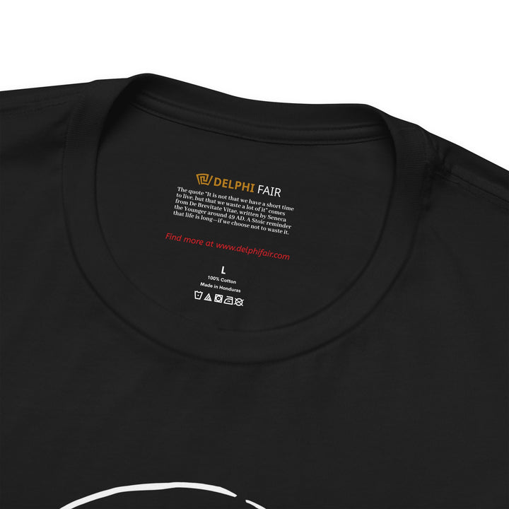 Close-up of a black t-shirt neck label featuring the phrase 'It is not that we have a short time to live, but that we waste a lot of it,' with a note about its meaning and origin from Seneca's letters written around 49 AD."