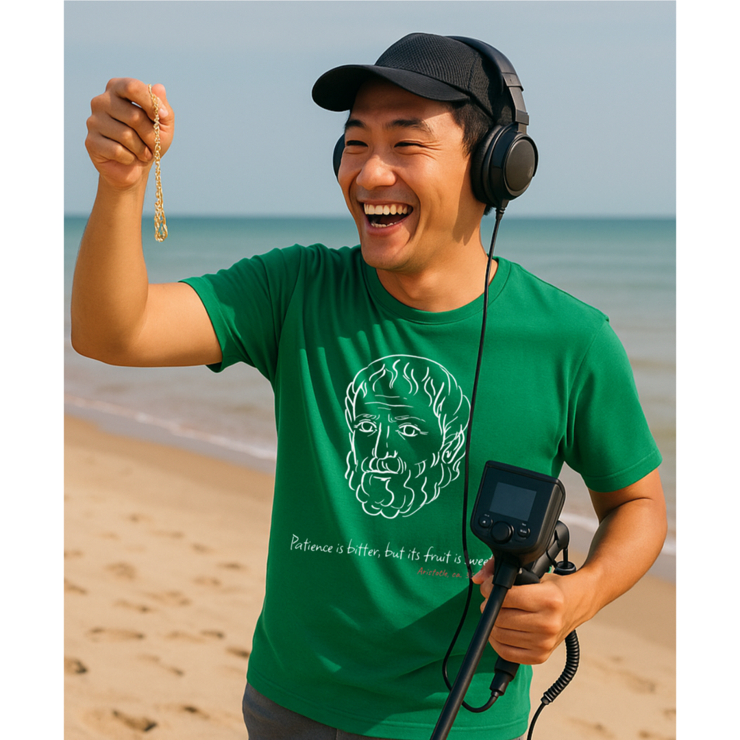 Man on the beach holding a metal detector and a gold bracelet, smiling. Wearing green t-shirt with white graphic of Aristotle, quote 'Patience is bitter, but its fruit is sweet,' and red text 'Aristotle ca. 350 BC'."