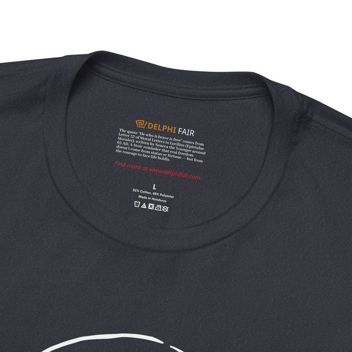 Close-up of a heather navy t-shirt neck label featuring the phrase 'He who is brave is free,' with a note about its meaning and origin from Seneca's letters written in 63 AD.
