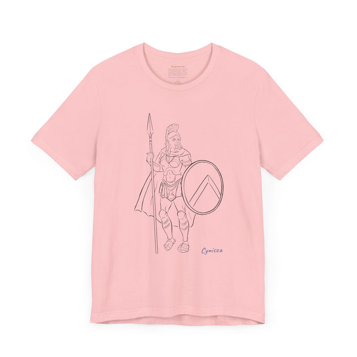 Pink t-shirt with a black line graphic of Cynisca standing in full Spartan armor, holding a spear and a round shield with a lambda symbol, with the blue text 'Cynisca' below the design.