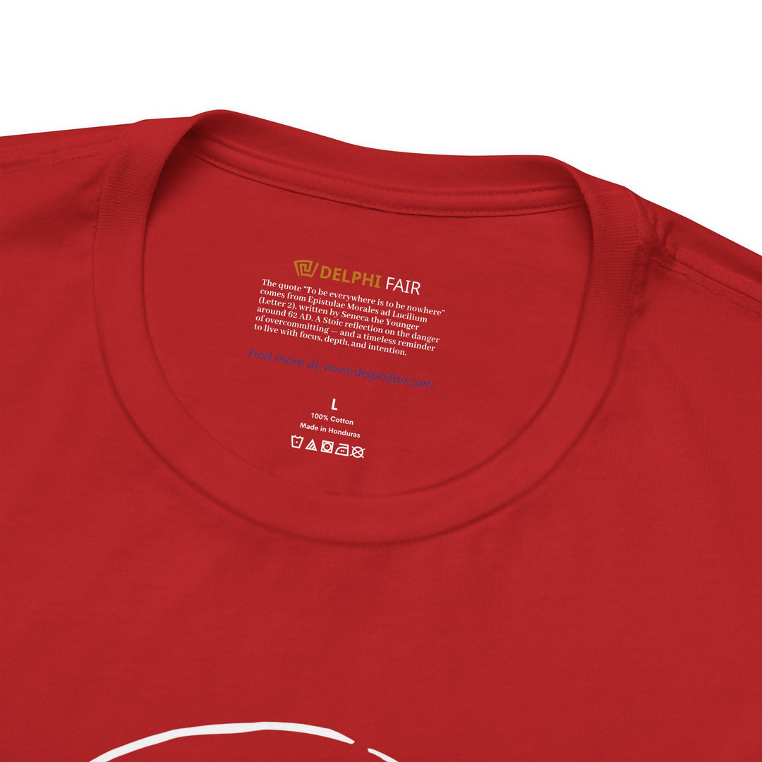 Close-up of a red t-shirt neck label featuring the phrase 'To be everywhere is to be nowhere,' with a note about its meaning and origin from Seneca's letters written around 62 AD.