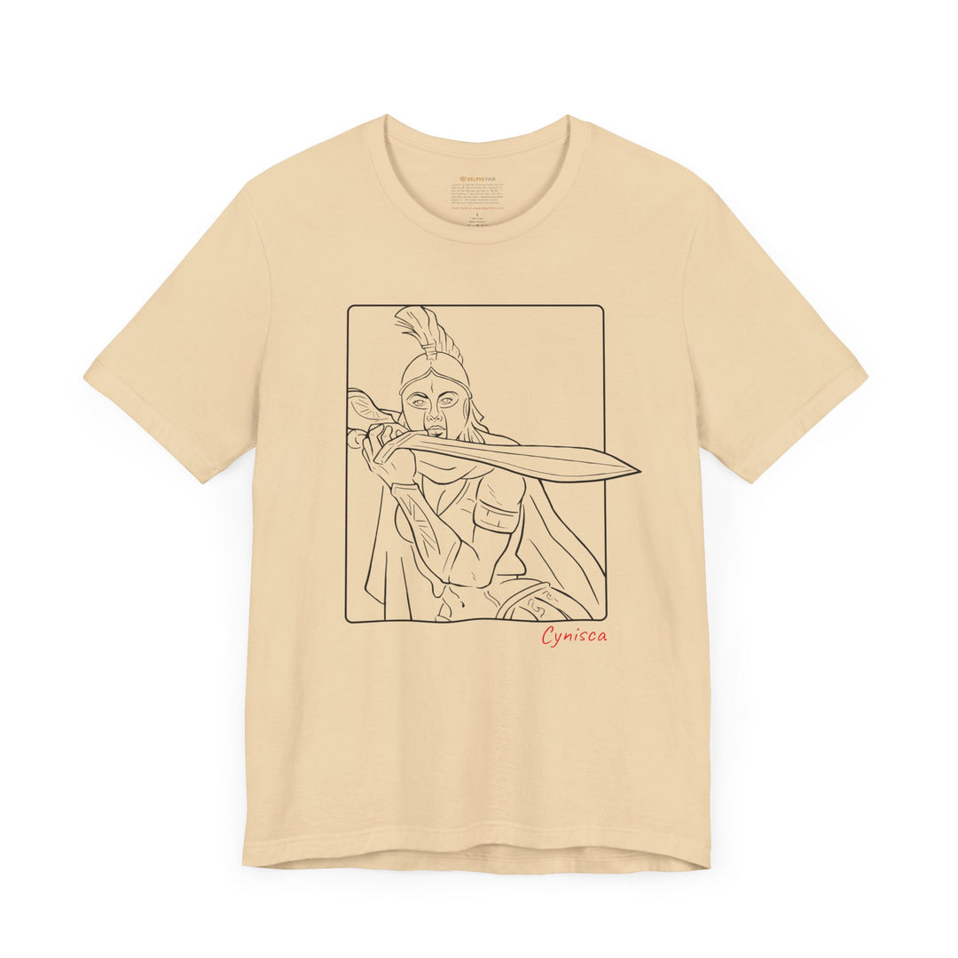 Soft-cream t-shirt with a black line graphic of Cynisca in a dramatic close-up pose, holding a sword across her chest inside a rectangular frame, with the red text 'Cynisca' below the design.