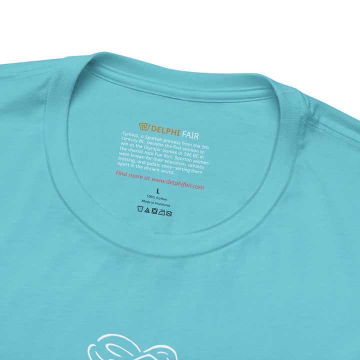 Close-up of a turquoise t-shirt neck label with the text about Cynisca, the first woman to win at the Olympic Games, and a fun fact about Spartan women being educated, athletic, and outspoken in the ancient world.