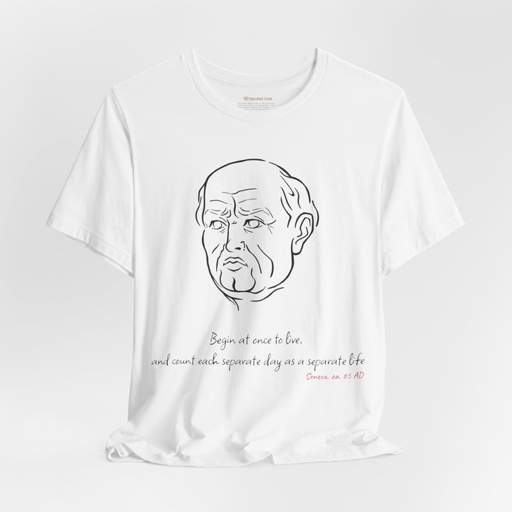 White t-shirt with a black graphic of Senecas' head, the quote 'Begin at once to live, and count each separate day as a separate life' and the red text 'Seneca, ca. 65 AD' below